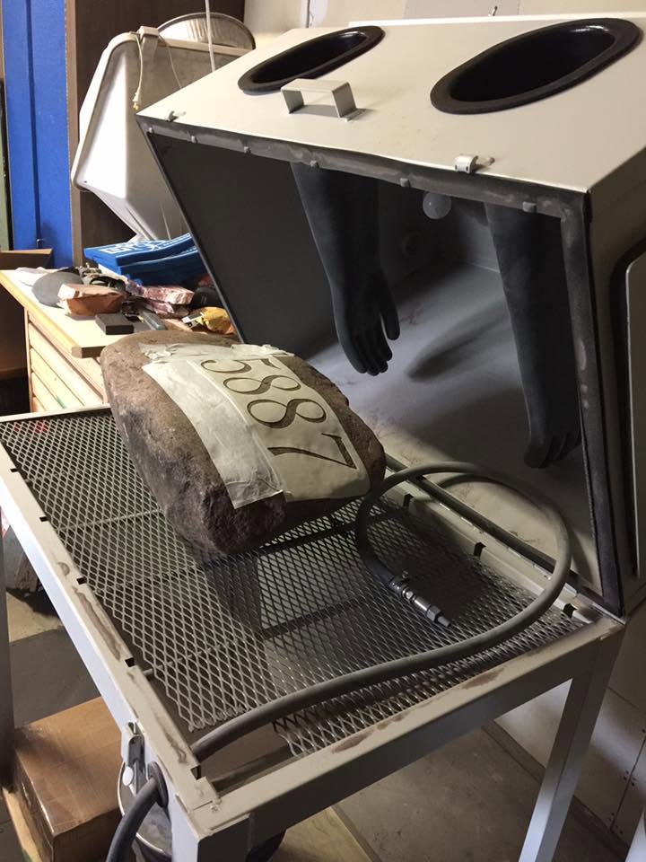 A stone in the sandblasting cabinet during the engraving process